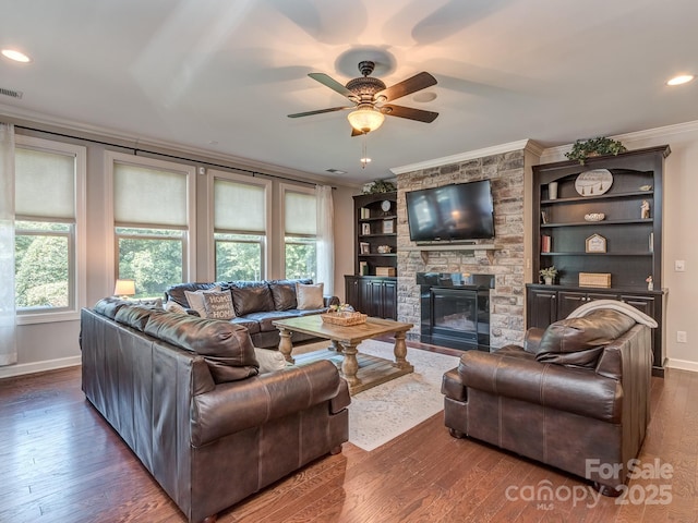 314 Candella Dr, Matthews, NC 28104 - living room featuring ornamental molding, dark wood finished floors, a stone fireplace, a ceiling fan, and baseboards