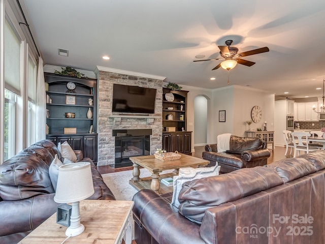 314 Candella Dr, Matthews, NC 28104 - living area featuring ornamental molding, a ceiling fan, a fireplace, arched walkways, and recessed lighting