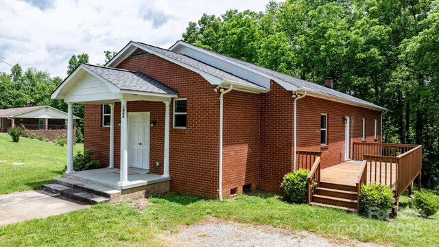 1844 Bellcroft Ln, Lenoir, NC 28645 - view of front of property featuring a front lawn, a wooden deck, brick siding, and a shingled roof