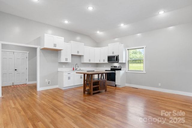1844 Bellcroft Ln, Lenoir, NC 28645 - kitchen with appliances with stainless steel finishes, white cabinetry, light countertops, light wood-style flooring, and vaulted ceiling
