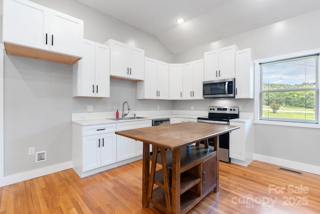 1844 Bellcroft Ln, Lenoir, NC 28645 - kitchen featuring stainless steel appliances, light countertops, vaulted ceiling, white cabinets, and recessed lighting