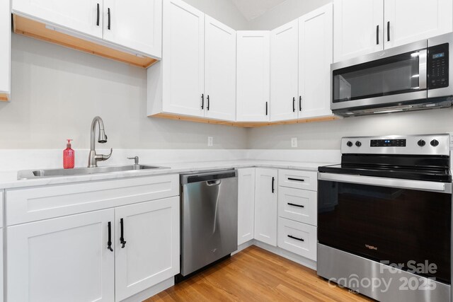 1844 Bellcroft Ln, Lenoir, NC 28645 - kitchen with stainless steel appliances, white cabinets, and light wood-type flooring