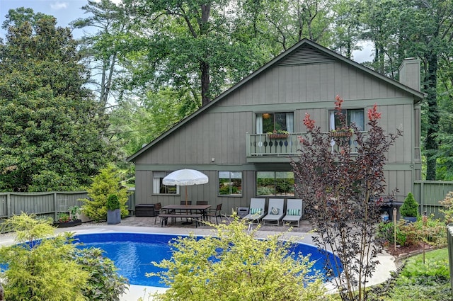 19 Poplar Ct, Hendersonville, NC 28792 - rear view of property featuring a patio area, a chimney, an outdoor pool, and view of scattered trees