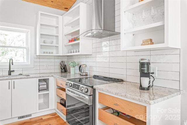 163 Hawk Hollow Dr, Lake Lure, NC 28746 - kitchen with stainless steel electric stove, island exhaust hood, open shelves, and white cabinets