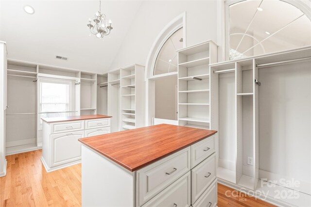 7301 Leharne Dr, Charlotte, NC 28270 - spacious closet with vaulted ceiling, light wood-style flooring, and a chandelier