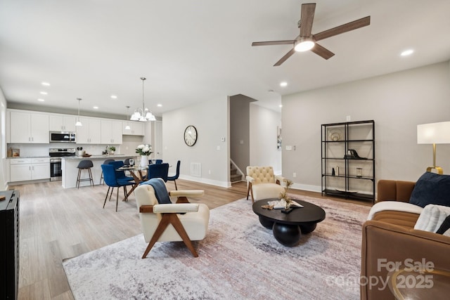 384 Speedway Pl, Concord, NC 28027 - living room featuring stairway, recessed lighting, light wood-style floors, a chandelier, and ceiling fan