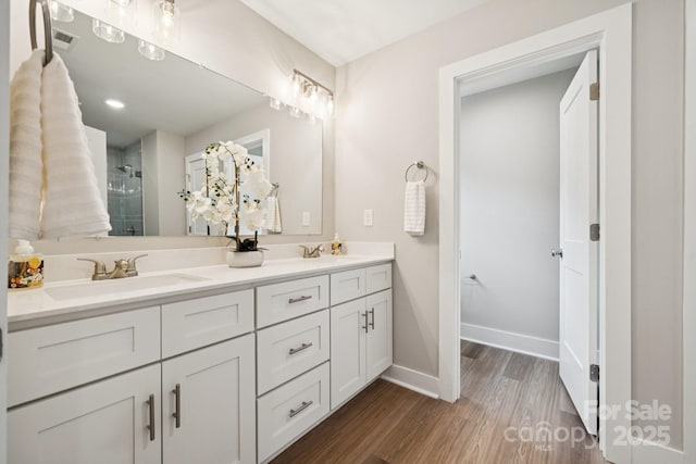384 Speedway Pl, Concord, NC 28027 - full bathroom with double vanity, a shower stall, and wood finished floors