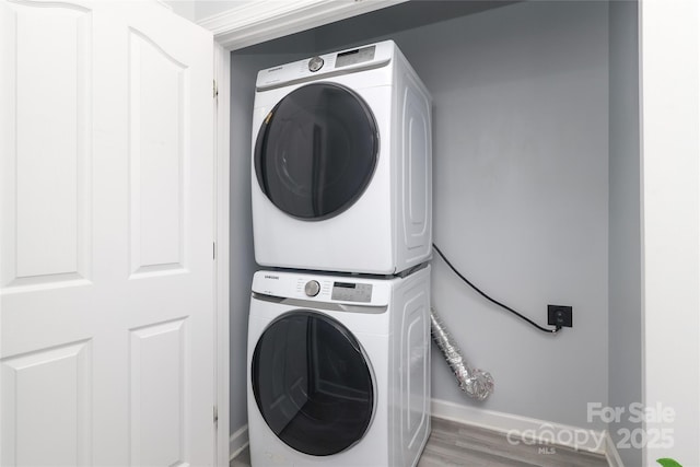 12321 Aquitaine St, Charlotte, NC 28277 - laundry area with stacked washer / drying machine and wood finished floors
