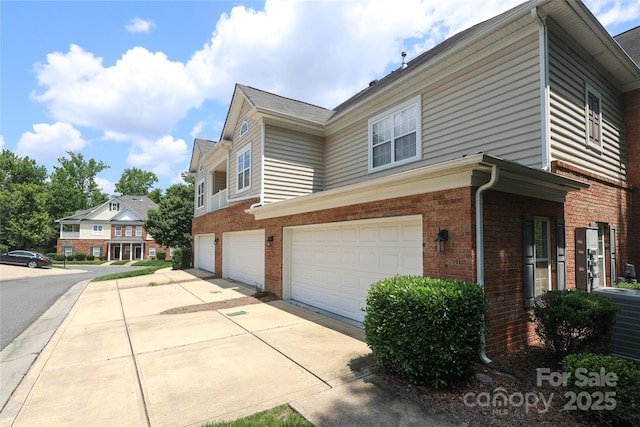 12321 Aquitaine St, Charlotte, NC 28277 - view of home's exterior featuring brick siding, a garage, and driveway