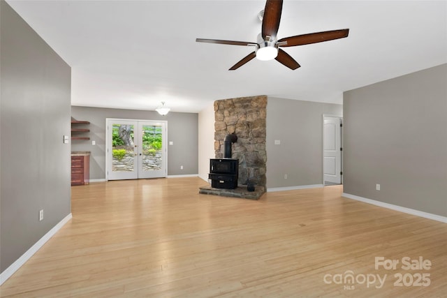 155 Old Starnes Cove Rd, Asheville, NC 28806 - unfurnished living room with a ceiling fan, a wood stove, and light wood-style floors