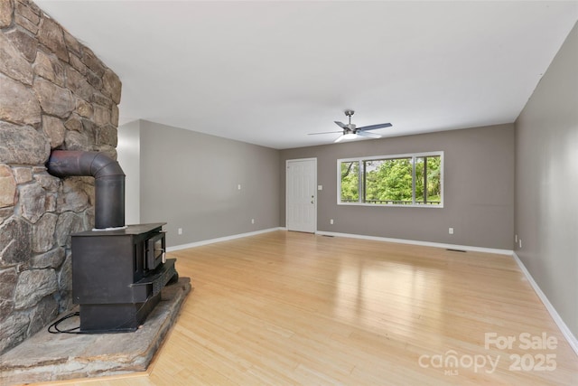 155 Old Starnes Cove Rd, Asheville, NC 28806 - unfurnished living room featuring wood finished floors, a wood stove, and ceiling fan