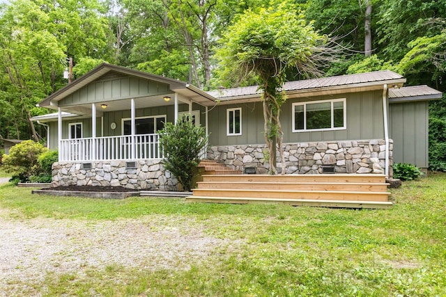155 Old Starnes Cove Rd, Asheville, NC 28806 - view of front of home featuring a metal roof, a porch, a front yard, board and batten siding, and stone siding