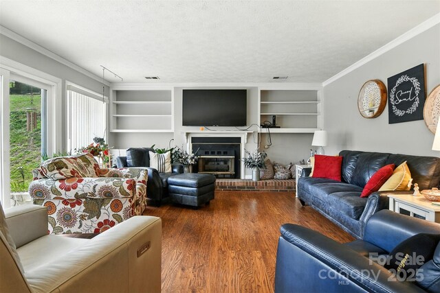 155 John Thomas Dr, Boone, NC 28607 - living room featuring crown molding, wood finished floors, built in shelves, a brick fireplace, and a textured ceiling