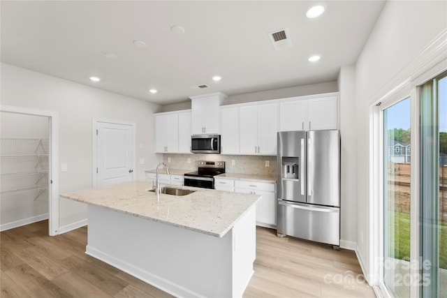 415 Luna Ln, Shelby, NC 28152 - kitchen with appliances with stainless steel finishes, an island with sink, tasteful backsplash, light wood finished floors, and white cabinets