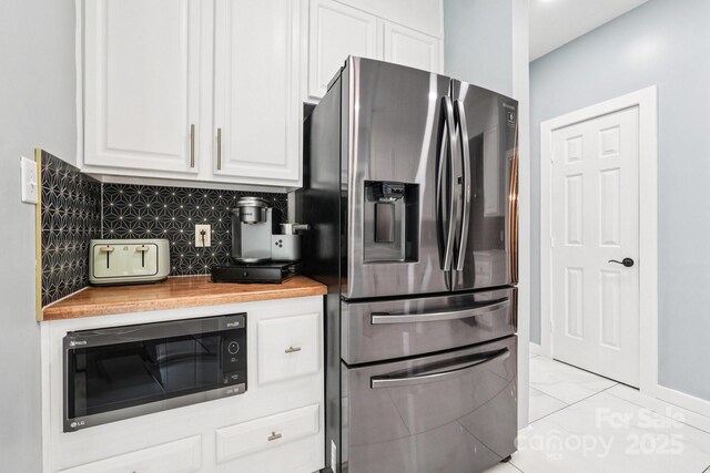 8618 Sam Dee Rd, Charlotte, NC 28215 - kitchen with stainless steel appliances, white cabinetry, butcher block countertops, and backsplash