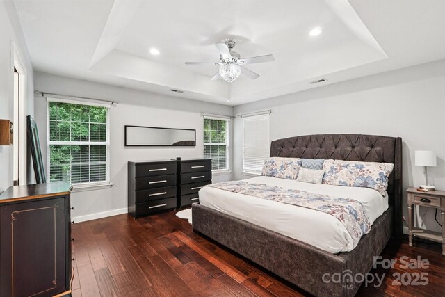 8618 Sam Dee Rd, Charlotte, NC 28215 - bedroom featuring a raised ceiling, dark wood finished floors, recessed lighting, multiple windows, and ceiling fan