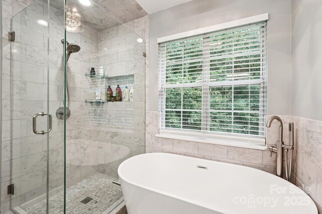 8618 Sam Dee Rd, Charlotte, NC 28215 - bathroom with tile walls, a freestanding bath, and a stall shower