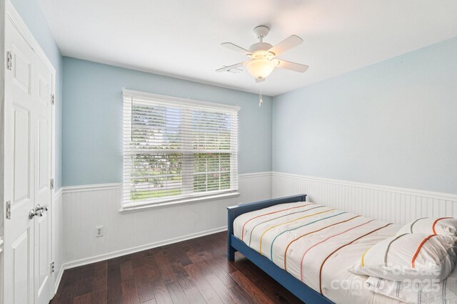 8618 Sam Dee Rd, Charlotte, NC 28215 - bedroom with a wainscoted wall, multiple windows, wood-type flooring, and a ceiling fan