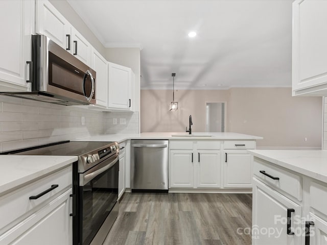 17136 Red Feather Dr, Charlotte, NC 28277 - kitchen featuring appliances with stainless steel finishes, crown molding, light wood finished floors, backsplash, and white cabinetry