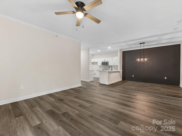 17136 Red Feather Dr, Charlotte, NC 28277 - unfurnished living room featuring dark wood-style floors, ornamental molding, recessed lighting, a ceiling fan, and a chandelier