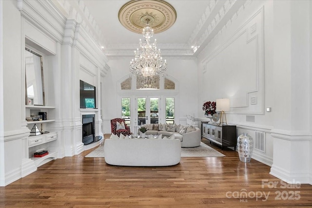 7068 Denison Rd, Summerfield, NC 27358 - living area featuring a fireplace, crown molding, wood finished floors, a decorative wall, and a chandelier