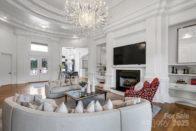 7068 Denison Rd, Summerfield, NC 27358 - living room featuring a chandelier, wood finished floors, a decorative wall, crown molding, and a fireplace with raised hearth
