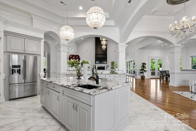 7068 Denison Rd, Summerfield, NC 27358 - kitchen with high end refrigerator, open floor plan, a chandelier, light stone countertops, and ornamental molding