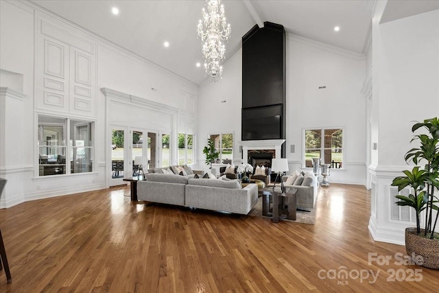 7068 Denison Rd, Summerfield, NC 27358 - living room featuring high vaulted ceiling, wood finished floors, a fireplace, a chandelier, and beam ceiling
