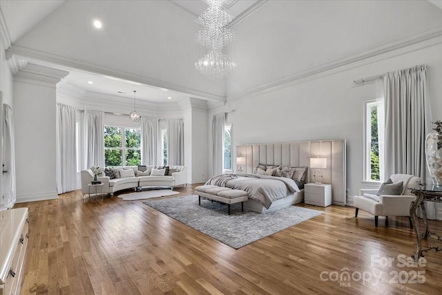 7068 Denison Rd, Summerfield, NC 27358 - bedroom with multiple windows, a high ceiling, wood finished floors, a chandelier, and ornamental molding