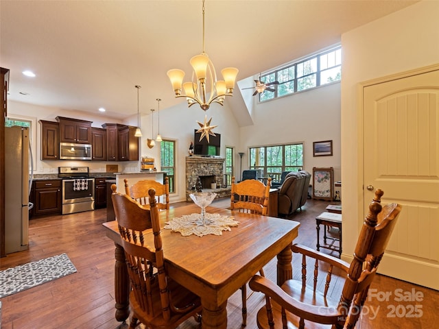 389 Manna Way, Sylva, NC 28779 - dining area with a fireplace, dark wood-type flooring, ceiling fan, recessed lighting, and a towering ceiling