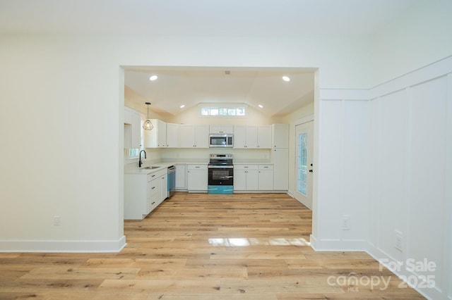 506 E Main St, Forest City, NC 28043 - kitchen with appliances with stainless steel finishes, lofted ceiling, light countertops, light wood-style flooring, and white cabinets