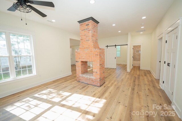 506 E Main St, Forest City, NC 28043 - unfurnished living room featuring ceiling fan, a barn door, light wood-style flooring, recessed lighting, and ornate columns