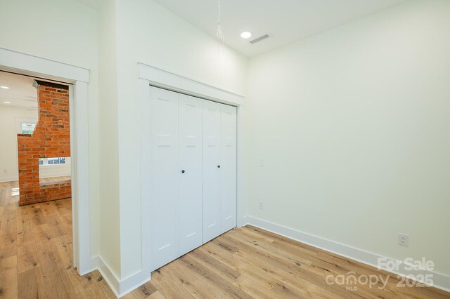 506 E Main St, Forest City, NC 28043 - unfurnished bedroom with light wood-type flooring, a closet, recessed lighting, and a glass covered fireplace