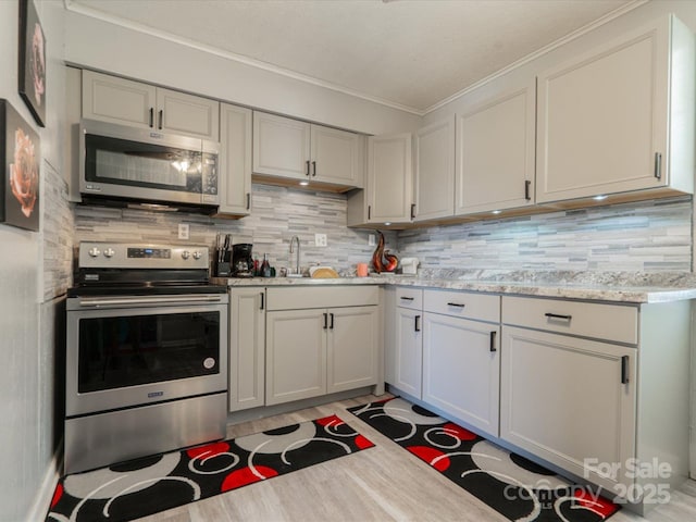 1035 Chesterfield Hwy, Cheraw, SC 29520 - kitchen with stainless steel appliances, ornamental molding, tasteful backsplash, light wood finished floors, and light stone countertops