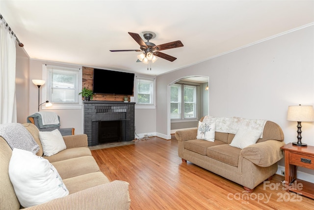 810 Maplewood Ave, Kannapolis, NC 28081 - living room featuring ornamental molding, light wood-style flooring, plenty of natural light, a ceiling fan, and a brick fireplace