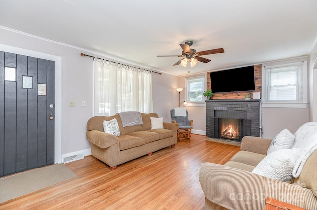 810 Maplewood Ave, Kannapolis, NC 28081 - living area featuring light wood-type flooring, a brick fireplace, ceiling fan, plenty of natural light, and crown molding