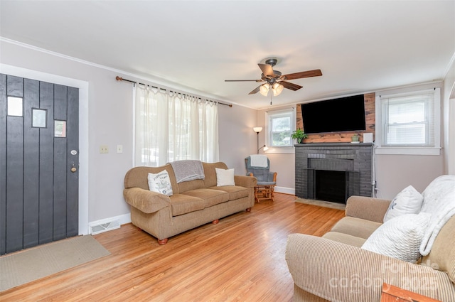 810 Maplewood Ave, Kannapolis, NC 28081 - living area with light wood-type flooring, a ceiling fan, a brick fireplace, plenty of natural light, and ornamental molding