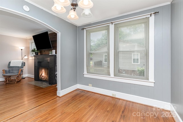 810 Maplewood Ave, Kannapolis, NC 28081 - living area featuring a brick fireplace, light wood-style floors, a chandelier, ornamental molding, and arched walkways