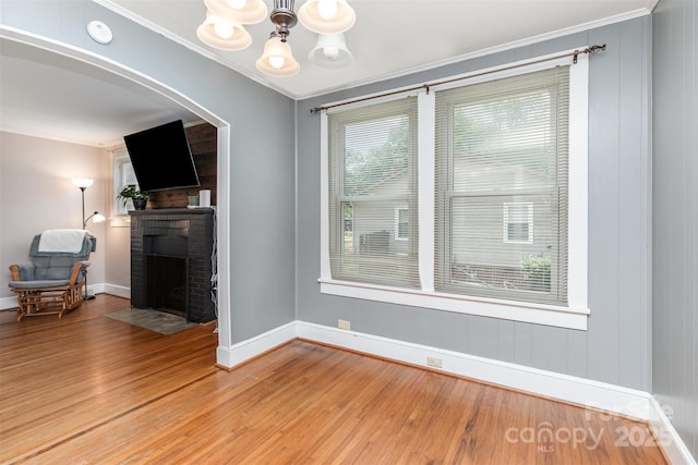 810 Maplewood Ave, Kannapolis, NC 28081 - living area featuring a fireplace, light wood finished floors, a chandelier, crown molding, and arched walkways