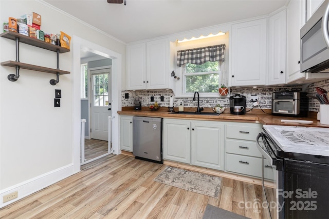 810 Maplewood Ave, Kannapolis, NC 28081 - kitchen with appliances with stainless steel finishes, decorative backsplash, light wood finished floors, butcher block countertops, and crown molding