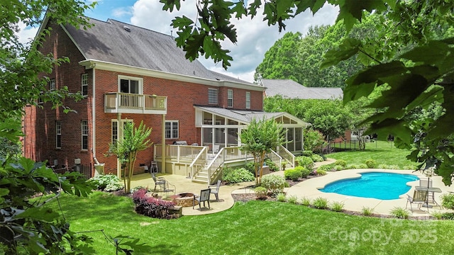 6006 Casswell Cir, Matthews, NC 28104 - back of property featuring an outdoor fire pit, a sunroom, brick siding, a patio, and an outdoor pool
