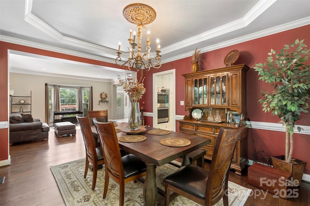 6006 Casswell Cir, Matthews, NC 28104 - dining space featuring a chandelier, wood finished floors, ornamental molding, and a tray ceiling