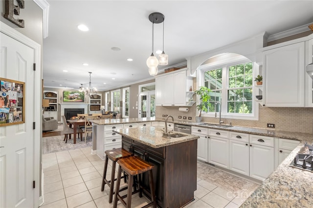 6006 Casswell Cir, Matthews, NC 28104 - kitchen featuring light tile patterned floors, crown molding, decorative backsplash, white cabinetry, and light stone counters