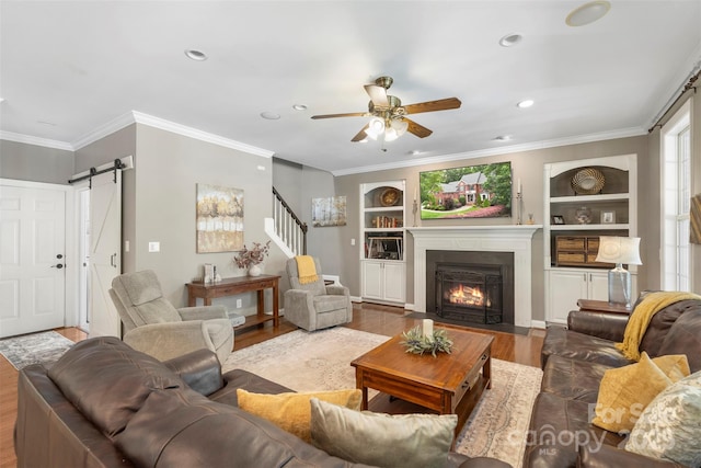 6006 Casswell Cir, Matthews, NC 28104 - living area featuring a barn door, wood finished floors, stairway, built in features, and ornamental molding