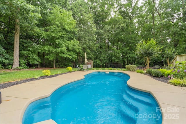 6006 Casswell Cir, Matthews, NC 28104 - outdoor pool featuring a storage unit, view of wooded area, and a yard