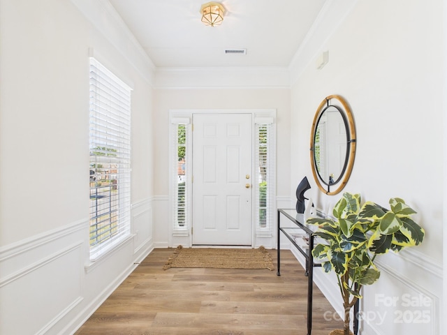 9030 Gander Dr, Charlotte, NC 28277 - entryway with wood finished floors, a wainscoted wall, crown molding, and a decorative wall