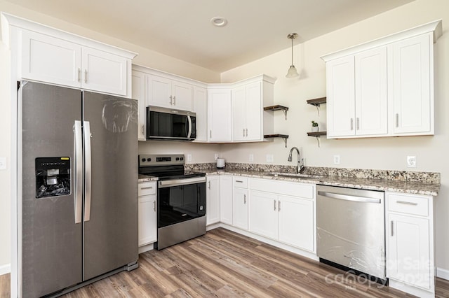 1214 Winter Pl SW, Lenoir, NC 28645 - kitchen featuring appliances with stainless steel finishes, wood finished floors, light stone countertops, open shelves, and white cabinets