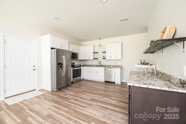 1214 Winter Pl SW, Lenoir, NC 28645 - kitchen with stainless steel appliances, open shelves, light wood finished floors, white cabinets, and recessed lighting