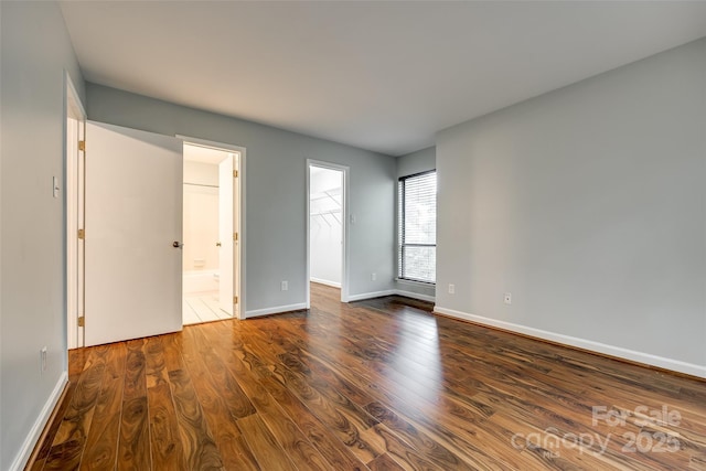 1606 Sharon Rd W Unit 40, Charlotte, NC 28210 - unfurnished bedroom with dark wood-style floors, a walk in closet, ensuite bathroom, and a closet