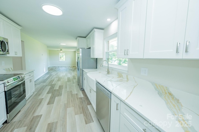 1696 Race Path Church Rd, Mooresboro, NC 28114 - kitchen featuring appliances with stainless steel finishes, white cabinets, light wood-style floors, healthy amount of natural light, and recessed lighting